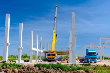 Vinçler-Mobil vinç montaj endüstriyel bina büyük beton iskelet var. Manzara dönüşümü makine ile kentsel alan kişi çalışıyor. Şantiye görüntülemek.