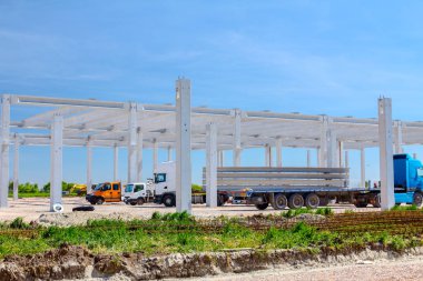 Kamyon römork ile uzun ve ağır beton kirişler için endüstriyel yapı inşaat sitesine taşıma.