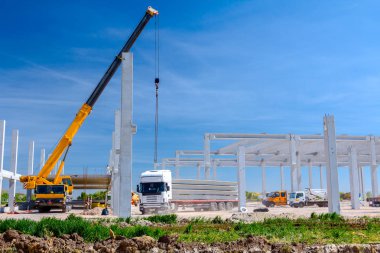 Vinçler-Mobil vinç montaj endüstriyel bina büyük beton iskelet var. Manzara dönüşümü makine ile kentsel alan kişi çalışıyor. Şantiye görüntülemek.