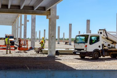 Görünüm grubunda inşaat işçileri ile emanet Yelekler ve site bina Duraklat, Sarı kask.