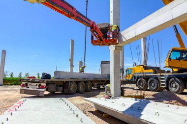 İşçi için derleme büyük inşaat beton kiriş yönetmek için Mobil vinç yardım ediyor.