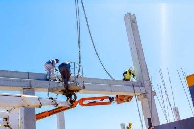 İşçi için derleme büyük inşaat beton kiriş yönetmek için Mobil vinç yardım ediyor.