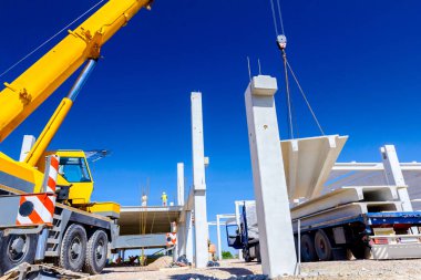 İşçi Vinç kanca kamyon römork gelen boşaltma beton kiriş için hazırlanıyor.