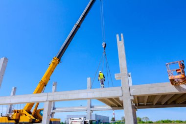 İşçi için derleme büyük inşaat beton kiriş yönetmek için Mobil vinç yardım ediyor.