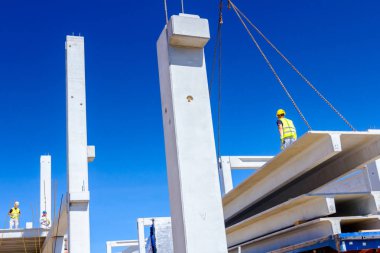 İşçi Vinç kanca kamyon römork gelen boşaltma beton kiriş için hazırlanıyor.