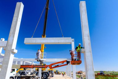 İşçi için derleme büyük inşaat beton kiriş yönetmek için Mobil vinç yardım ediyor.