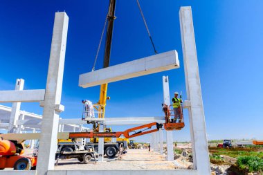 İşçi için derleme büyük inşaat beton kiriş yönetmek için Mobil vinç yardım ediyor.