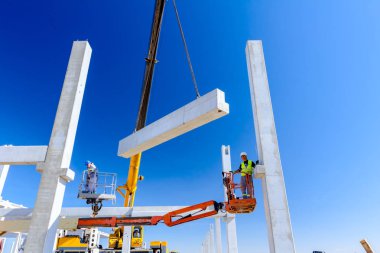 İşçi için derleme büyük inşaat beton kiriş yönetmek için Mobil vinç yardım ediyor.