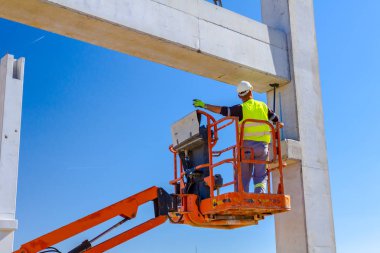 İşçi için derleme büyük inşaat beton kiriş yönetmek için Mobil vinç yardım ediyor.