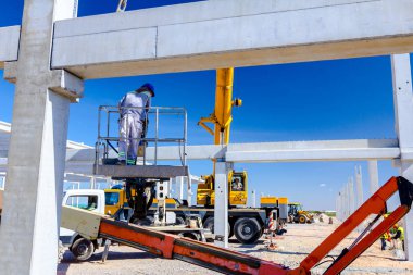 Rigger yüksek kiraz toplayıcıda. İnşaat alanının üzerinden geçiyor..