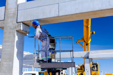 İşçi için derleme büyük inşaat beton kiriş yönetmek için Mobil vinç yardım ediyor.