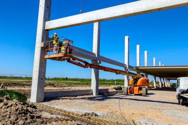 İşçi için derleme büyük inşaat beton kiriş yönetmek için Mobil vinç yardım ediyor.