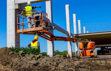 İşçi için derleme büyük inşaat beton kiriş yönetmek için Mobil vinç yardım ediyor.