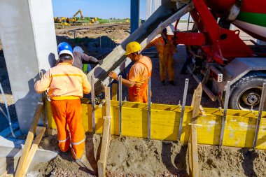 Site oluşturma, işçi Beton Mikser Kamyon uzun kalıp içinde yağıyor.