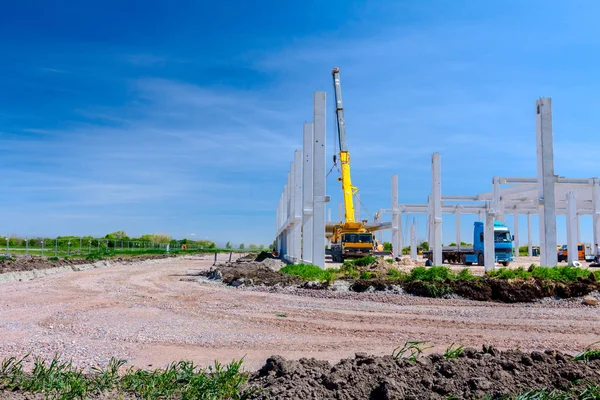 Vinçler-Mobil vinç montaj endüstriyel bina büyük beton iskelet var. Manzara dönüşümü makine ile kentsel alan kişi çalışıyor. Şantiye görüntülemek.