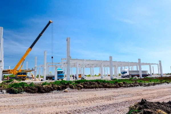 Vinçler-Mobil vinç montaj endüstriyel bina büyük beton iskelet var. Manzara dönüşümü makine ile kentsel alan kişi çalışıyor. Şantiye görüntülemek.