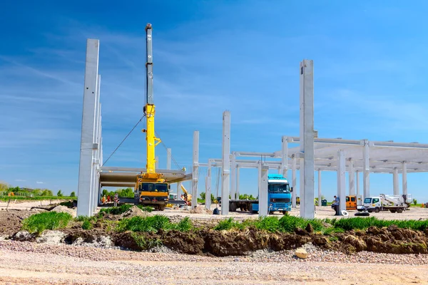 Vinçler-Mobil vinç montaj endüstriyel bina büyük beton iskelet var. Manzara dönüşümü makine ile kentsel alan kişi çalışıyor. Şantiye görüntülemek.