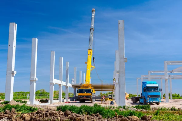 Vinçler-Mobil vinç montaj endüstriyel bina büyük beton iskelet var. Manzara dönüşümü makine ile kentsel alan kişi çalışıyor. Şantiye görüntülemek.