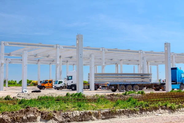 Kamyon römork ile uzun ve ağır beton kirişler için endüstriyel yapı inşaat sitesine taşıma.