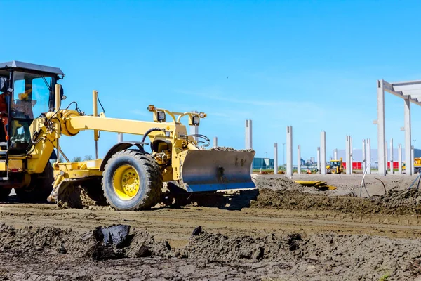 Santral sarı çizgili araç kullanıyor. İnşaat alanındaki zemini düzleştiriyor..