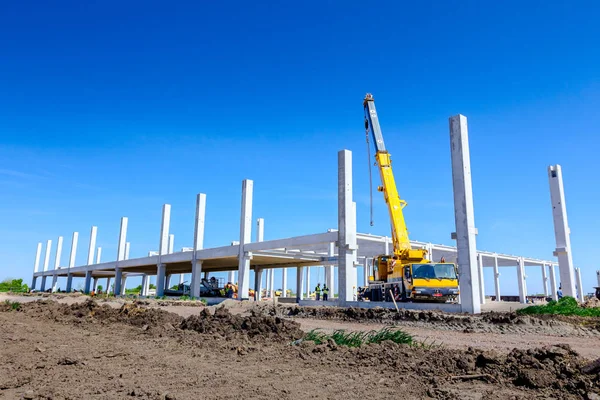 Vinçler-Mobil vinç montaj endüstriyel bina büyük beton iskelet var. Manzara dönüşümü makine ile kentsel alan kişi çalışıyor. Şantiye görüntülemek.