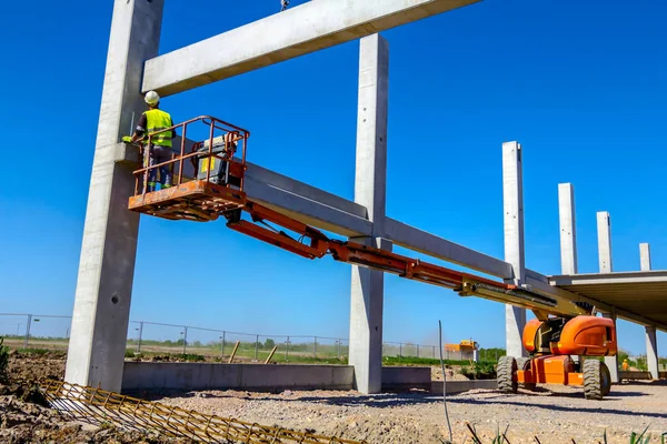 İşçi için derleme büyük inşaat beton kiriş yönetmek için Mobil vinç yardım ediyor.