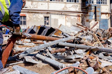 İşçi oksijen ve asetilen ve propan karıştırarak atık metali gazla kesiyor..