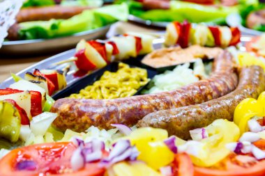 Taze sebze ile dekore edilmiş sosis geleneksel sosis turnuva üzerinde sunulur.