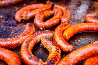 Barbekü plaka üzerinde lezzetli sulu sosis pişirme