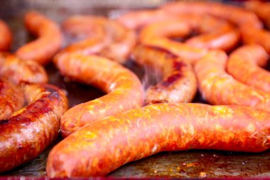 Barbekü plaka üzerinde lezzetli sulu sosis pişirme