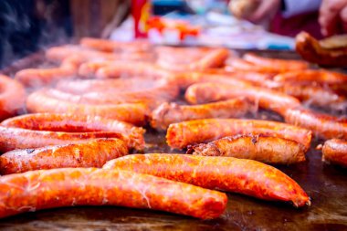 Barbekü plaka üzerinde lezzetli sulu sosis pişirme