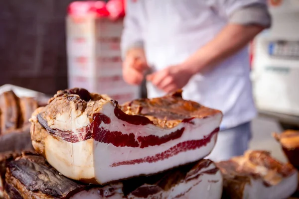 Säljer rökt bacon, kött på stall, gatumarknad — Stockfoto