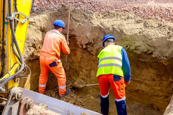 Travailleur utilise la pelle pour mettre en place les bonnes mesures dans la tranchée carrée — Photo