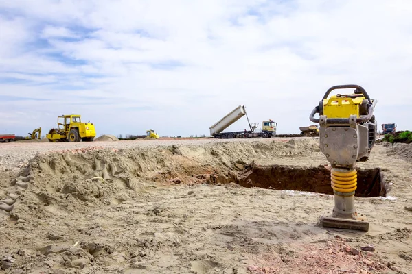 Petite pilonneuse jaune usagée debout compacteur de sol au siège du bâtiment — Photo