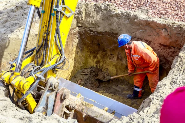 Travailleur utilise la pelle pour mettre en place les bonnes mesures dans la tranchée carrée — Photo