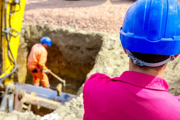 Boss oversees, controlling worker who is using shovel to set up — Stock Photo, Image