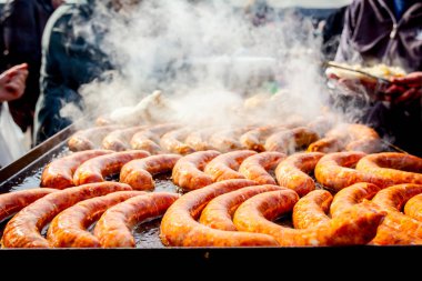 Büyük Barbekü plaka üzerinde lezzetli sulu sosis pişirme, dumanlı