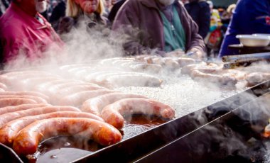 Büyük Barbekü plaka üzerinde lezzetli sulu sosis pişirme, dumanlı