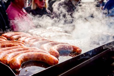 Büyük Barbekü plaka üzerinde lezzetli sulu sosis pişirme, dumanlı