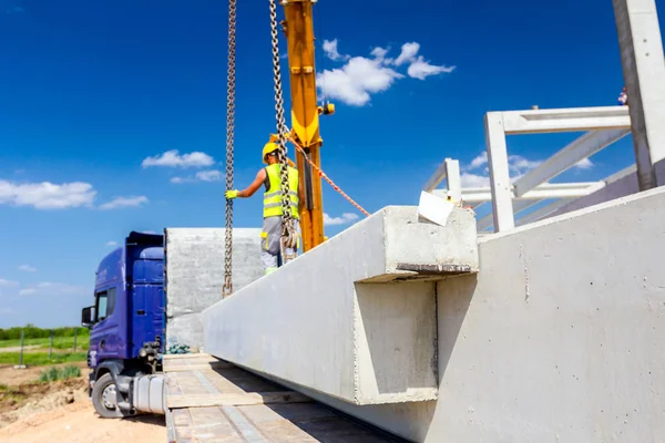 Werknemer is het bevestigen van kraanhaken aan beton joist in vrachtwagen trail — Stockfoto