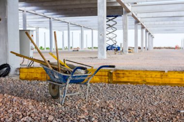 Alet, kürek ve tırmıkla inşaat alanında el arabası. 