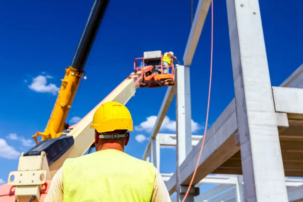 İşçiler vinç 'e yerden yardım ediyor, dengeyi sağlayın ve yönetin.