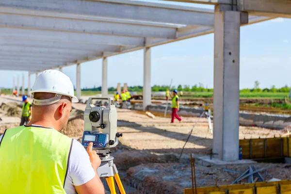 Engenheiro civil, geodésico está trabalhando com estação total em um bui — Fotografia de Stock