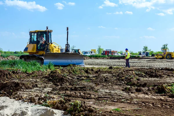 Bulldozer está nivelando el terreno en el sitio de construcción — Foto de Stock