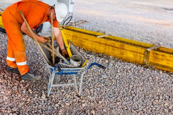 Worker is gathering tools, shovel, and rake in wheelbarrow at bu — Stock Photo, Image