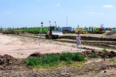 Bir şantiyede tripod üzerinde geodesist cihaz