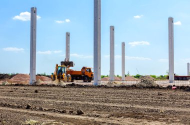 Ekskavatör şantiyede ön kova ile bir kamyon yükleniyor