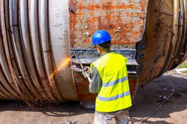İşçi eski metal endüstriyel ekipmanları asetilen ile kesiyor 