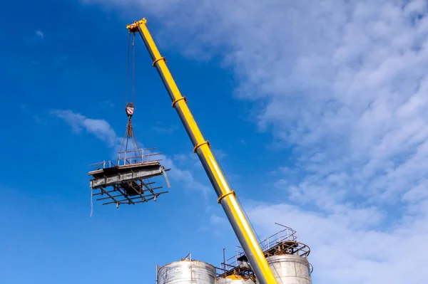 Mobile crane lowering part of a big old metal truss — Stock Photo, Image