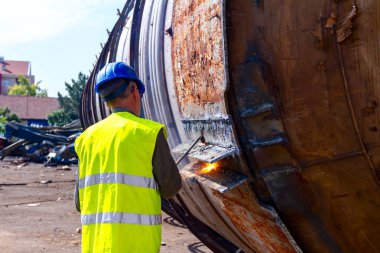 İşçi eski metal endüstriyel ekipmanları asetilen ile kesiyor 